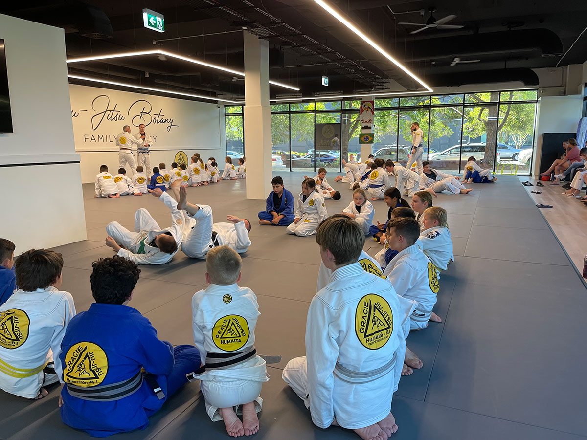 teenagers brazilian jiu jitsu classes at gracie botany instructor showing technique students in a circle